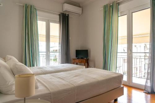 una camera da letto con un grande letto con tende verdi di Acropolis Now! 2BR in central Athens ad Atene