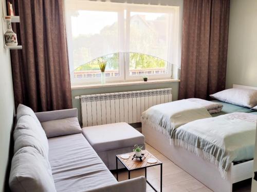 a room with two beds and a couch and a window at Pokoje gościnne u Brody in Międzybrodzie Żywieckie
