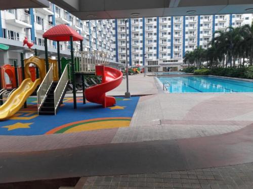 een speeltuin met een glijbaan en een zwembad bij Casa Lim SMDC Light Residences Tower 3 in Manilla