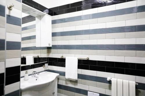 ナポリにあるJordan Homeの黒と白のタイル張りの壁のバスルーム(シンク付)