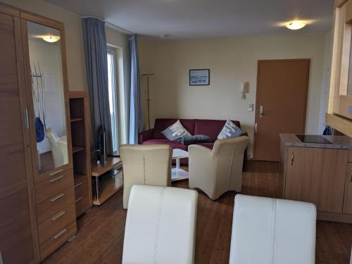 ein Wohnzimmer mit einem Sofa, einem Tisch und Stühlen in der Unterkunft Yachthafenresidenz - Wohnung 6201 / 742 in Kühlungsborn