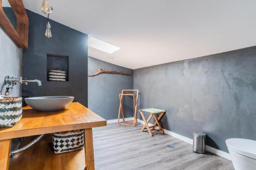 La salle de bains est pourvue d'un lavabo sur une table en bois. dans l'établissement Casa Alfambras - Holiday Cottage in Aljezur, à Aljezur