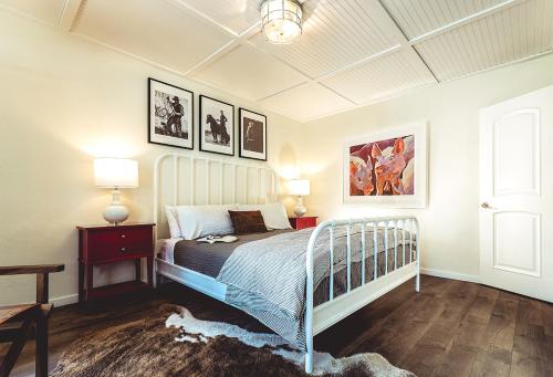 a bedroom with a bed and some pictures on the wall at Stables Inn in Paso Robles