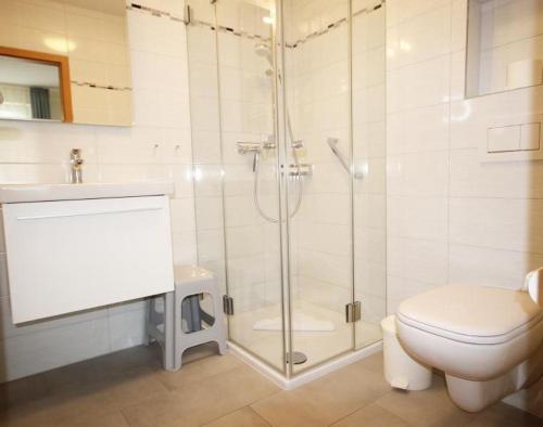 a bathroom with a shower and a toilet and a sink at Yachthafenresidenz-Wohnung-6106-824 in Kühlungsborn