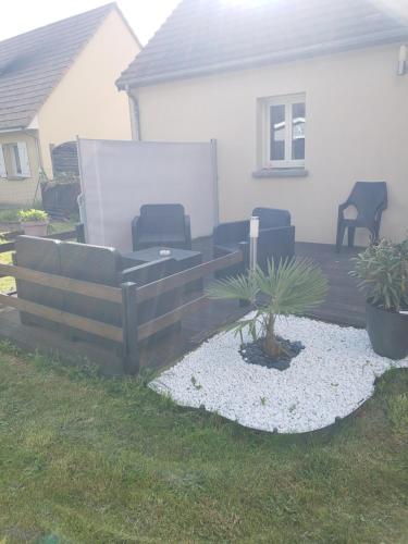 - une terrasse en bois avec un canapé et des chaises dans la cour dans l'établissement Chambre dans logement privé, à Yvré-le-Pôlin