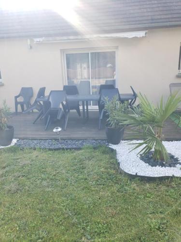 un patio avec des chaises et une table sur une terrasse dans l'établissement Chambre dans logement privé, à Yvré-le-Pôlin