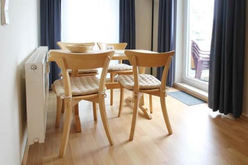 キュールングスボルンにあるYachthafenresidenz-Wohnung-7201-838のダイニングテーブル(椅子4脚、テーブル1台付)、窓