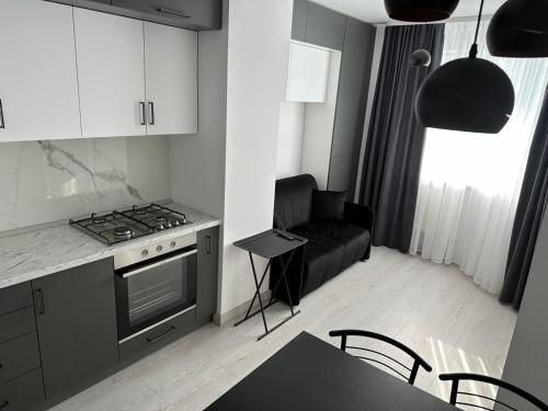 a kitchen with a black couch and a stove top oven at Квартира по вул. Огієнка 2а in Lutsk