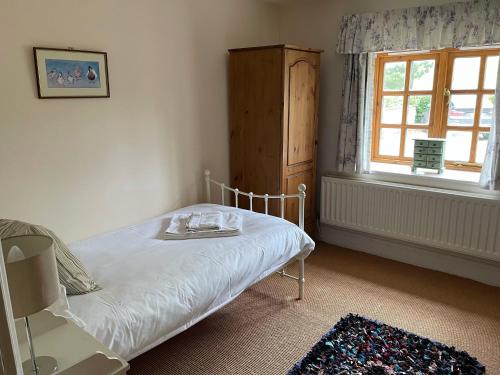 a small bedroom with a bed and a window at Elm Tree Cottage in Salton