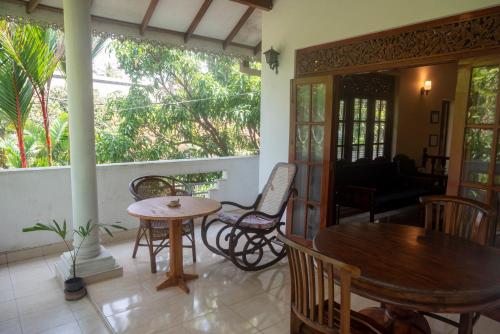 un soggiorno con tavoli, sedie e portico di The Tourist Balcony a Negombo