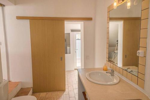 a bathroom with a sink and a toilet and a mirror at Colors Pool House in Carvoeiro