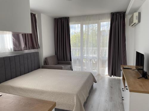 um quarto de hotel com uma cama e uma janela em Студио Симона 5 първа линия море em Lozenets