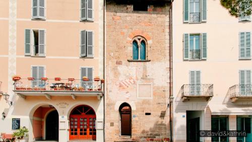 a building with a balcony and red doors at Casa Angiolina - Holidays in Morcote