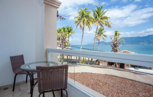 uma varanda com mesa e cadeiras e vista para o oceano em Hotel Mercedes em Ilhabela