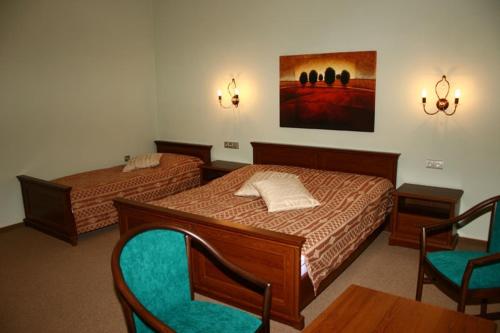 a bedroom with two beds and two chairs in it at Zlaty Lev in Louny