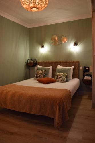 a bedroom with a large bed with orange sheets and pillows at Logis Hôtel-Restaurant Le Relais in Hauterives
