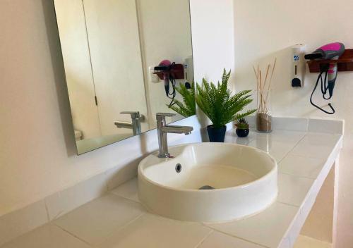 a bathroom with a white sink and a mirror at Las Veraneras Villas & Resort in Acajutla