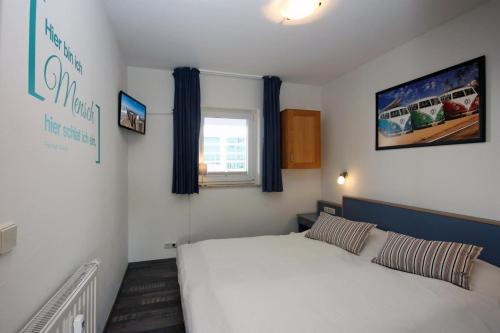 ein Schlafzimmer mit einem weißen Bett und einem Fenster in der Unterkunft Yachthafenresidenz - Wohnung 9103 / 879 in Kühlungsborn