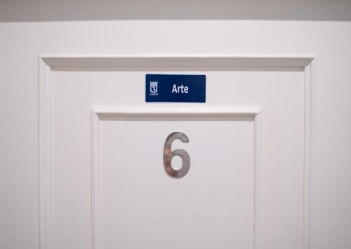 una señal azul sobre una puerta con el número seis en Guest House Éxito en Madrid, en Madrid