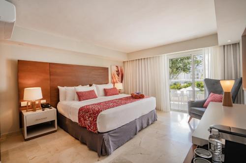 a bedroom with a large bed and a chair at Emotions by Hodelpa Puerto Plata in San Felipe de Puerto Plata