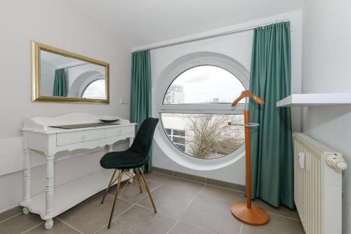 キュールングスボルンにあるYachthafenresidenz-Wohnung-9308-891のデスク、鏡付きの窓が備わる客室です。