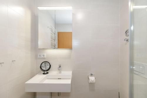 a white bathroom with a sink and a mirror at Yachthafenresidenz-Wohnung-9308-891 in Kühlungsborn