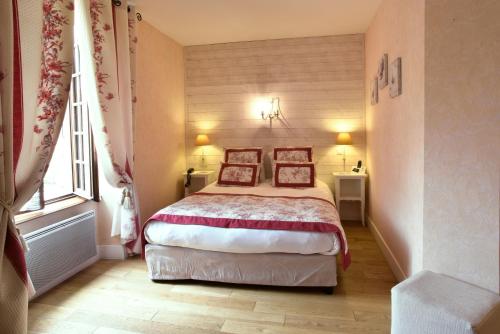 a bedroom with a bed with two pillows on it at Logis Hôtel-Restaurant Le Relais in Hauterives