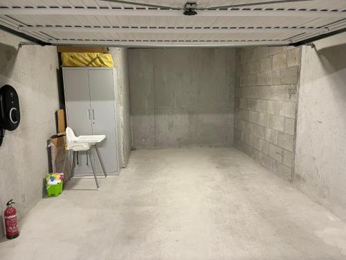 an empty room with a white chair in a room at BELLA CRUZ 66 m2 prestations premium, wifi, balcon, parking avec borne de recharge électrique, plage Prieuré, Commerces in Dinard
