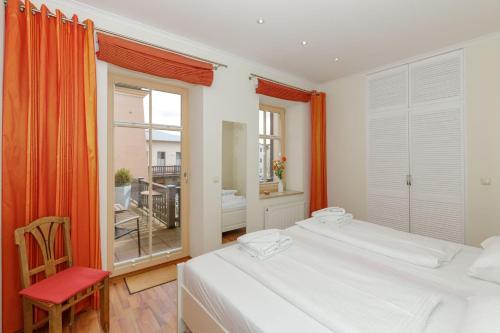 キュールングスボルンにあるResidenz-Seestern-Wohnung-7-931のベッドルーム1室(ベッド2台、赤い椅子付)