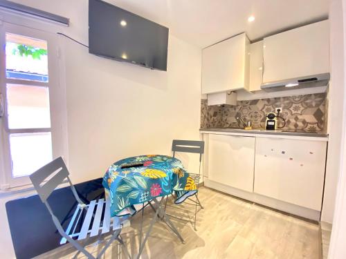 une cuisine avec des armoires blanches et une table et des chaises dans l'établissement Mini Studio - Le Panisse By SCLS Locations, à Cannes