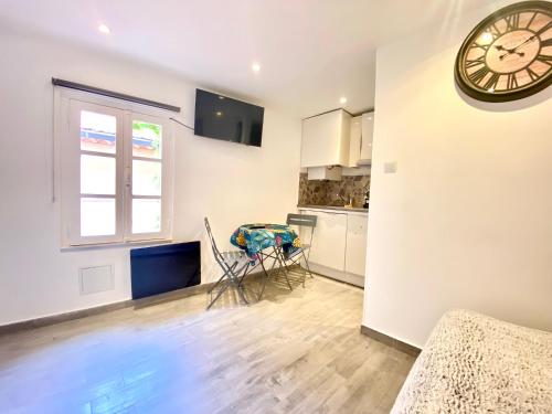 une chambre avec une horloge au mur et une cuisine dans l'établissement Mini Studio - Le Panisse By SCLS Locations, à Cannes