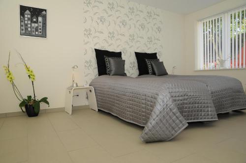 a bedroom with a bed with a gray comforter at Hotel CoCo Aps in Esbjerg