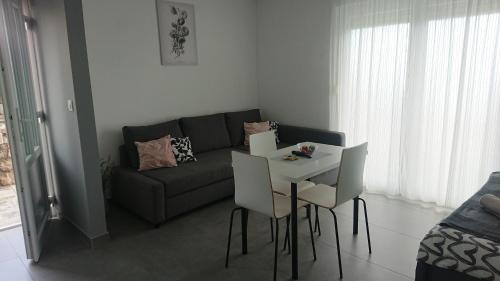 - un salon avec un canapé, une table et des chaises dans l'établissement Studio apartman Kastav Hill, à Kastav
