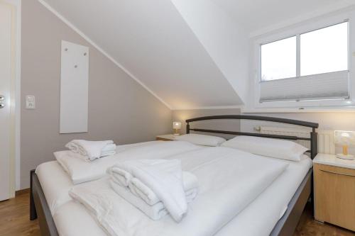 キュールングスボルンにあるAm-Stadtwald-Wohnung-23-9790のベッドルーム1室(ベッド1台、白いタオル付)