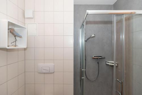ein Bad mit einer Dusche mit einem Vogel an der Wand in der Unterkunft Yachthafenresidenz - Wohnung 8105 / 9733 in Kühlungsborn