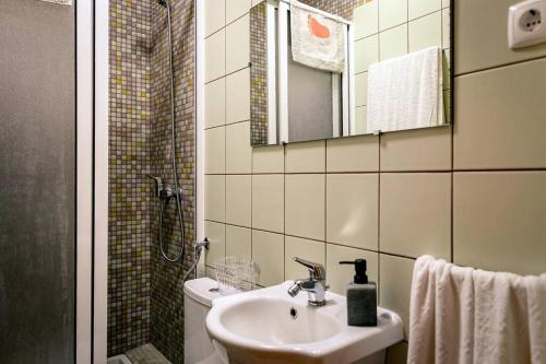 W łazience znajduje się umywalka, toaleta i lustro. w obiekcie Casa Silveira Mar w mieście Angra do Heroísmo