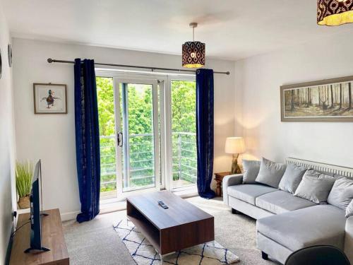a living room with a couch and a large window at Riverside Apartment with Parking 1 Mile from Town Centre in Kent