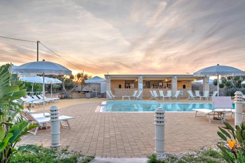 ein Resort mit einem Pool, Stühlen und Sonnenschirmen in der Unterkunft Hotel Reverse in Torre Santa Sabina