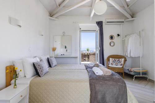 1 dormitorio con 2 camas y ventana grande en Vainas Belvedere Villa, en Skopelos Town