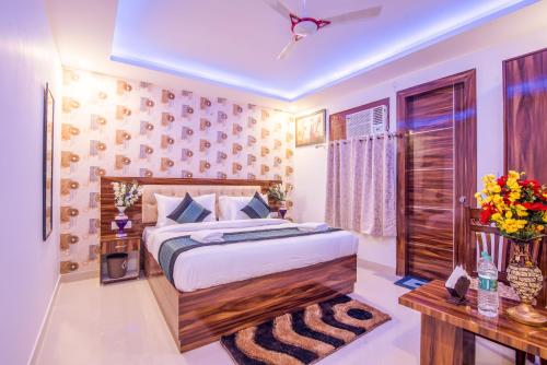een slaapkamer met een groot bed en een tafel bij Hotel Festival Mahipalpur At Delhi Airport in New Delhi