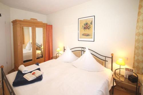 ein Schlafzimmer mit einem weißen Bett mit zwei Handtüchern darauf in der Unterkunft Strandstraße 16 - Wohnung 33 / 9877 in Kühlungsborn