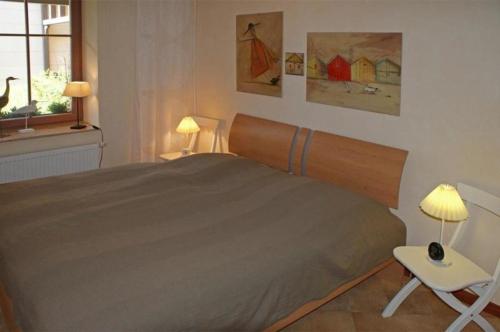 キュールングスボルンにあるResidenz-Seestern-WE-18-mit-WLAN-9917のベッドルーム1室(ベッド1台、テーブル、椅子付)