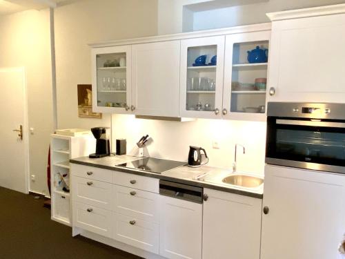 a kitchen with white cabinets and a sink at Residenz-Ostseewind-Wohnung-17-255 in Kühlungsborn