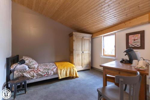 Chambre d'hôte de la petite toscane d'Auvergne في Isserteaux: غرفة نوم بسرير وسقف خشبي