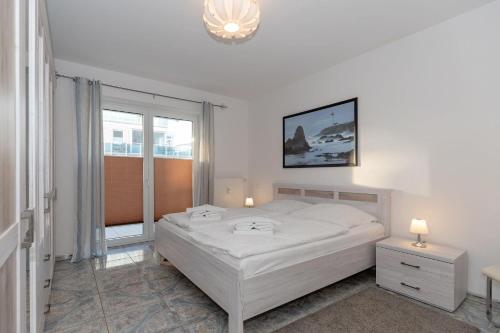 キュールングスボルンにあるAm-Yachthafen-Villa-Fehmarn-Wohnung-38-586の白いベッドルーム(ベッド1台、窓付)