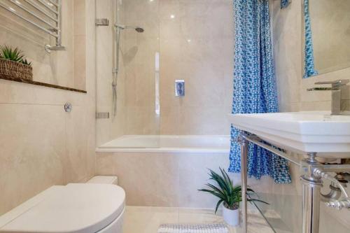 La salle de bains est pourvue de toilettes, d'un lavabo et d'une douche. dans l'établissement MODERN 2 BED 2 BATH CLOSE TO OXFORD STREET, à Londres