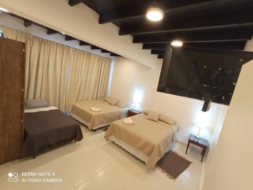 a bedroom with two beds and a flat screen tv at Edificio O'Hara Ap3 in Ciudad del Este