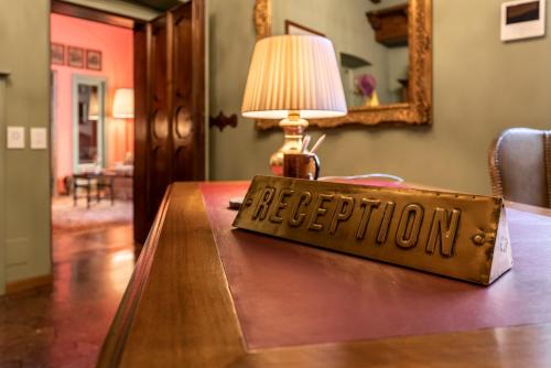 a sign on a table with a lamp on it at FORESTERIA di PALAZZO RADICI in Bergamo