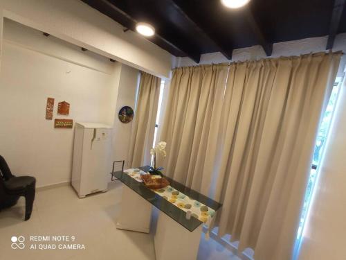 ein Wohnzimmer mit einem Tisch und einem Vorhang in der Unterkunft Edificio O'Hara Ap3 in Ciudad del Este