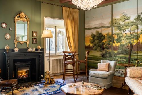 a living room with a fireplace and a chandelier at FORESTERIA di PALAZZO RADICI in Bergamo